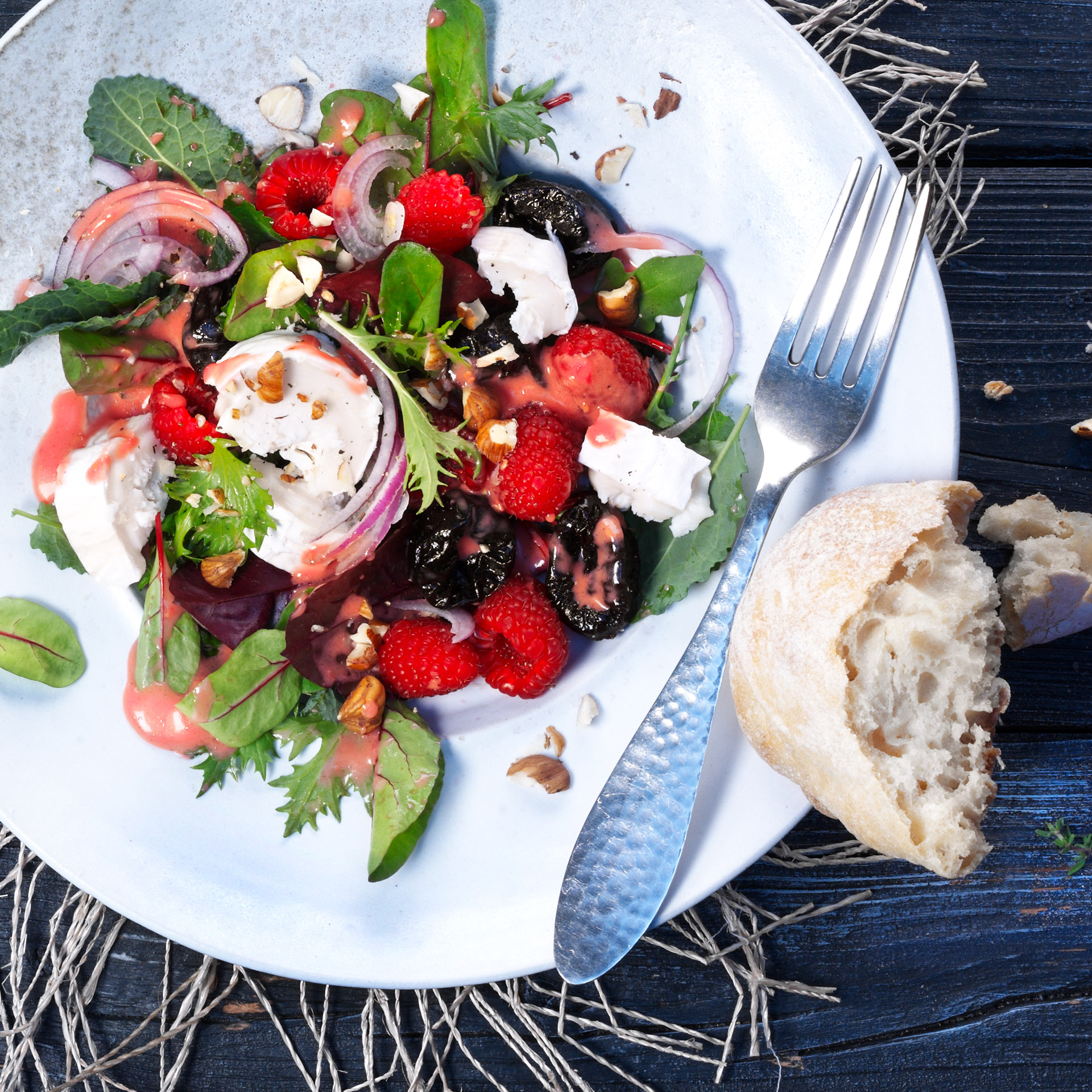 Prunes and goat cheese are a classic pairing any time of the year. Make this salad in the winter by substituting roasted, diced beets in place of the raspberries.